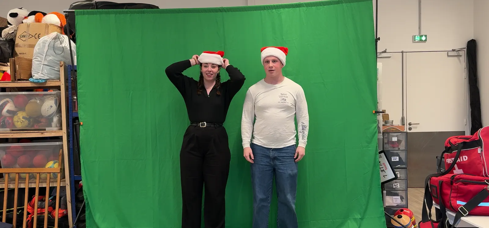 Le tournage de décembre : les deux présentateurs en bonnet de Noël devant le fond vert